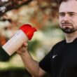 Odżywka białkowa w szklance z łyżką miarową i składnikami